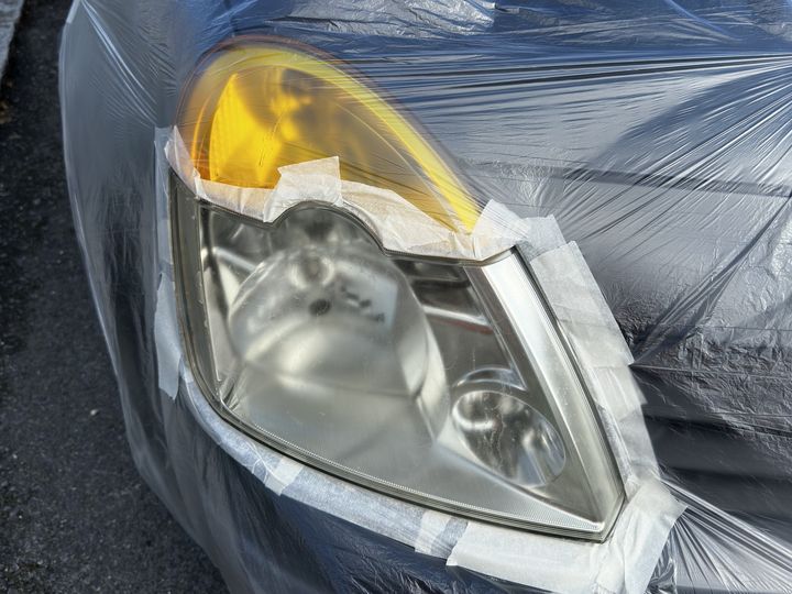 Optique avant jaunie par les UV, carrosserie masquée au ruban pendant la rénovation